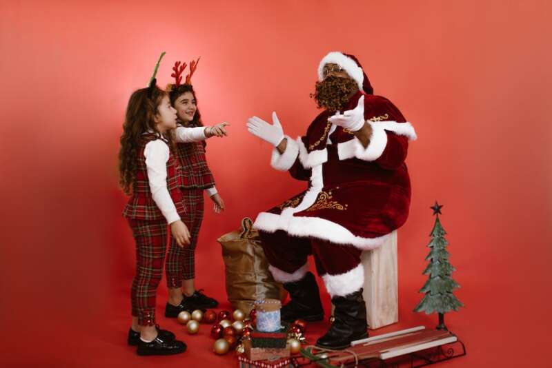 Immagine di Babbo Natale che porta doni a dei bambini felici durante il Natale