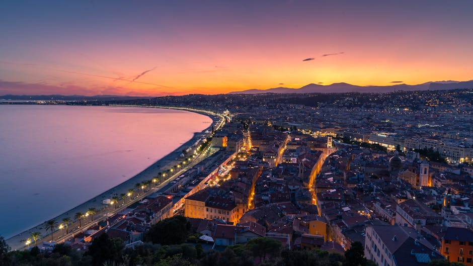 La Promenade des Anglais di Nizza con palme, spiaggia e il Mar Mediterraneo